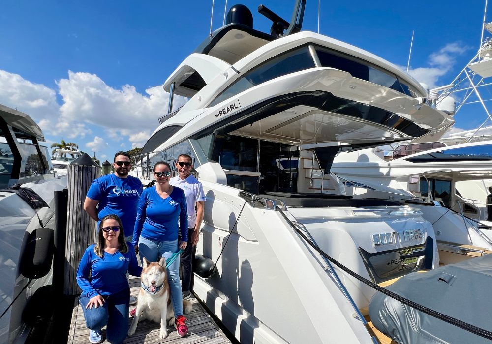Marine electronics team standing beside the luxury yacht PEARL at a Fort Lauderdale marina, with a Siberian Husky on the dock—symbolizing OnBoat Marine’s commitment to high-end yacht electrical and electronic installations.